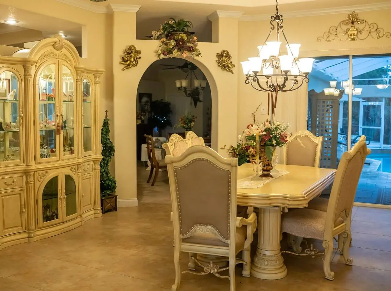 Elegant dining room with classic cream furniture and chandelier.