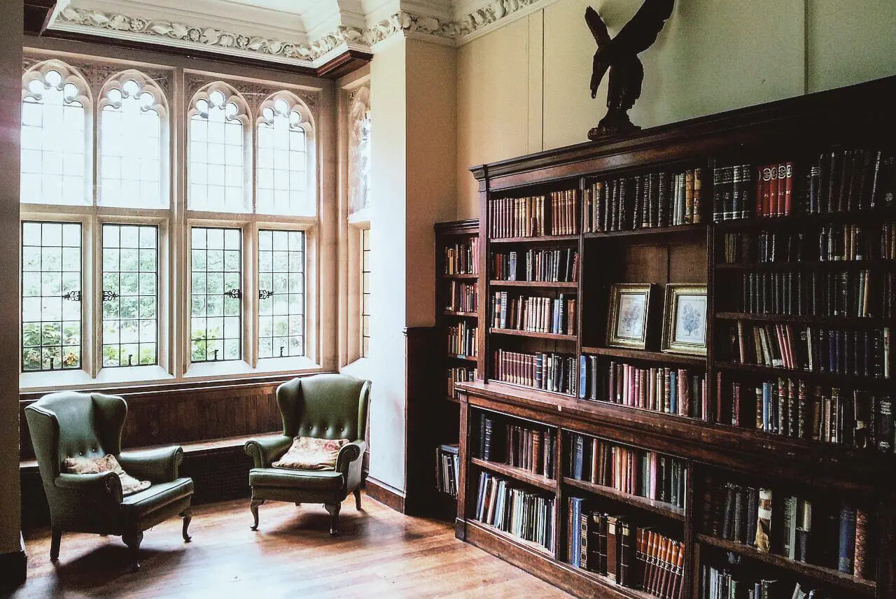 Cozy vintage library corner with a leather armchair and large wooden bookshelves.