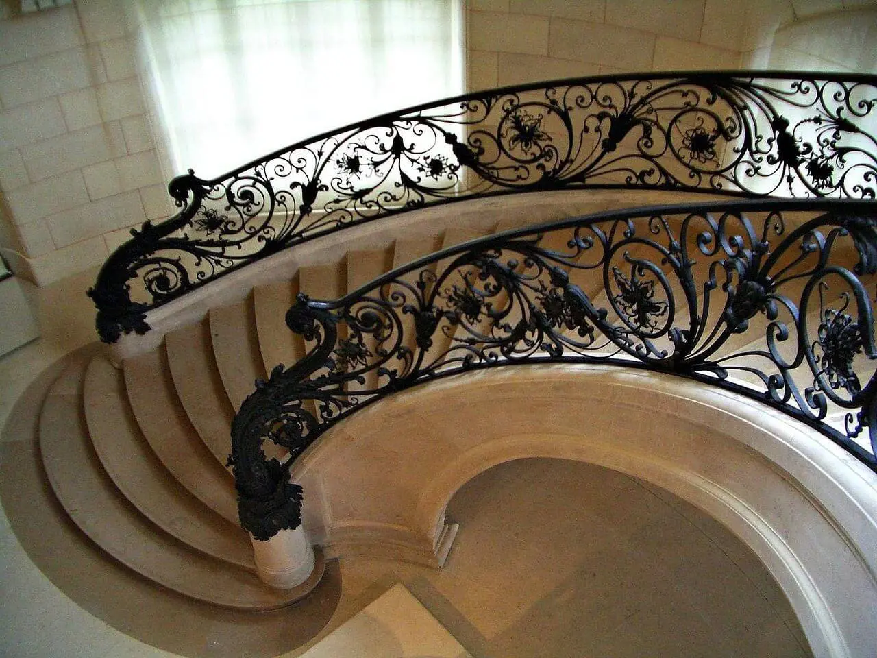 Elegant spiral staircase with ornate iron railing.